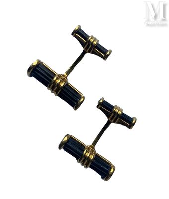 two pairs of black and gold cufflinks on a white background