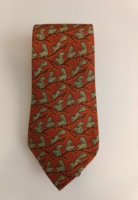an orange neck tie with a green paisley design on it