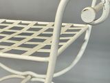 a white metal chair with a basket on the back of it
