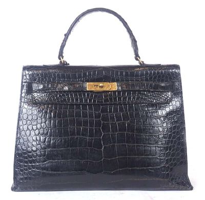 a black crocodile skin handbag with gold hardware on the handle