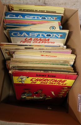 a lot of books in a cardboard box on the floor