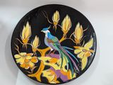 a plate with a bird painted on it sitting on a table