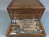 a wooden box with silverware in it on a table