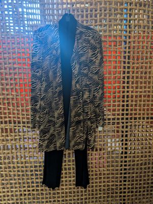black and white animal print jacket and leggings hanging on a wicker wall