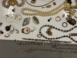 many different types of necklaces and bracelets laid out on a table