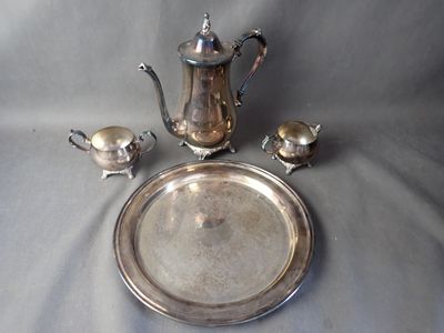 a silver plate with a silver tea pot and a silver plate with a silver tea pot and a silver plate with a silver tea pot and a silver plate