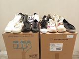 many pairs of shoes sitting on top of a cardboard box