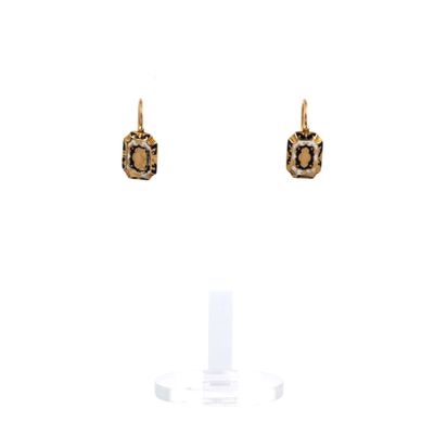 gros plan d'une paire de boucles d'oreilles sur un support