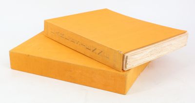 deux livres jaunes empilés l'un sur l'autre sur une surface blanche