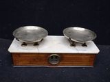 pair of antique silver plated scales on wooden stand on black background