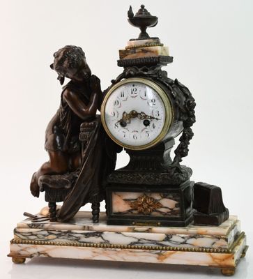 une statue représentant une femme assise sur un banc à côté d'une horloge