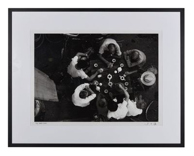 photographie en noir et blanc d'un groupe de personnes assises autour d'une table