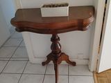 une petite table sur laquelle se trouve une boîte, dans un coin d'une pièce