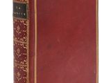 un vieux livre à la couverture rouge et à la bordure dorée