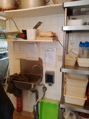 un homme debout dans une cuisine, près d'un évier