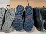 five pairs of men ' s hiking shoes lined up on a cardboard box