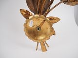 a gold vase with a flower in it on a table