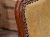 a close up of a wooden chair with a yellow upholstered seat
