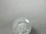 a clear glass object on a table with a gray background