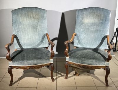 pair of blue upholstered chairs in a room with tile flooring