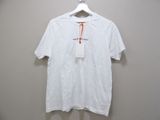 Le t-shirt blanc est suspendu à un cintre accroché au mur.
