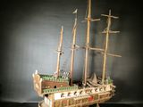 a wooden model of a ship on a black surface