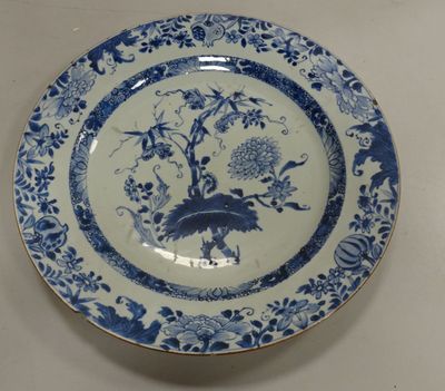 a blue and white plate with a bird and flowers on it