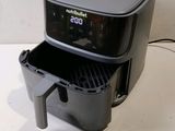 a black air fryer sitting on a white counter