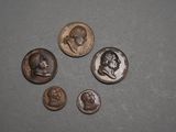 four different types of coins on a table with one of them in the middle