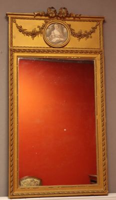 a mirror with a gold frame and a red wall