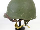 an old green helmet on a black stand on a white background