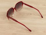 a close up of a pair of sunglasses on a wooden surface