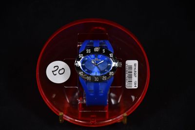 une montre bleue dans un écrin rouge posé sur une surface noire