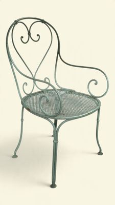 une chaise verte dont le dossier et les accoudoirs ont la forme d'un cœur
