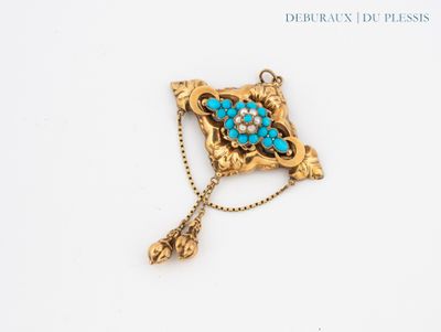 an image of a gold broochle with turquoise stones on it