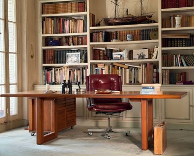 a desk with a chair in front of a bookshelf