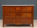 an antique chest of drawers with marble top and brass pulls