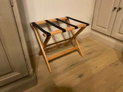 un petit porte-bagages en bois dans un coin de la pièce
