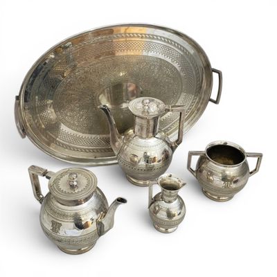 silver plated tea set with teapots, cups, and saucer