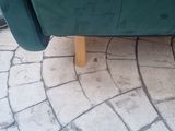 a green couch that is sitting on a brick floor