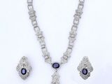 une photo d'un ensemble composé d'un collier et de boucles d'oreilles sertis de saphirs
