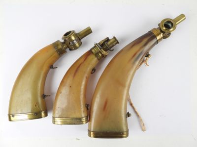 trois cornes anciennes ornées de laiton sur fond blanc