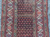 an antique persian rug with a red and blue design