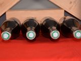 four bottles of wine are lined up in a row on a table