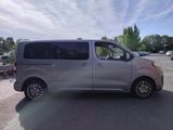 the silver van is parked on the side of the road in the parking lot