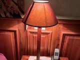 une petite table sur laquelle est posée une lampe, à côté d'un lit
