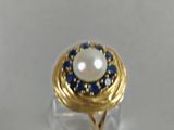 an image of a ring with a pearl and blue sapphires
