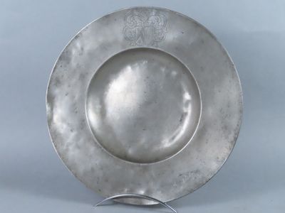 a silver plate on a metal stand on a blue background