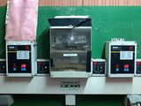 four ovens on a shelf with a pink bag in front of them