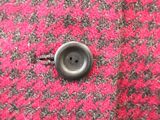 a close up of a button on a red and black jacket
